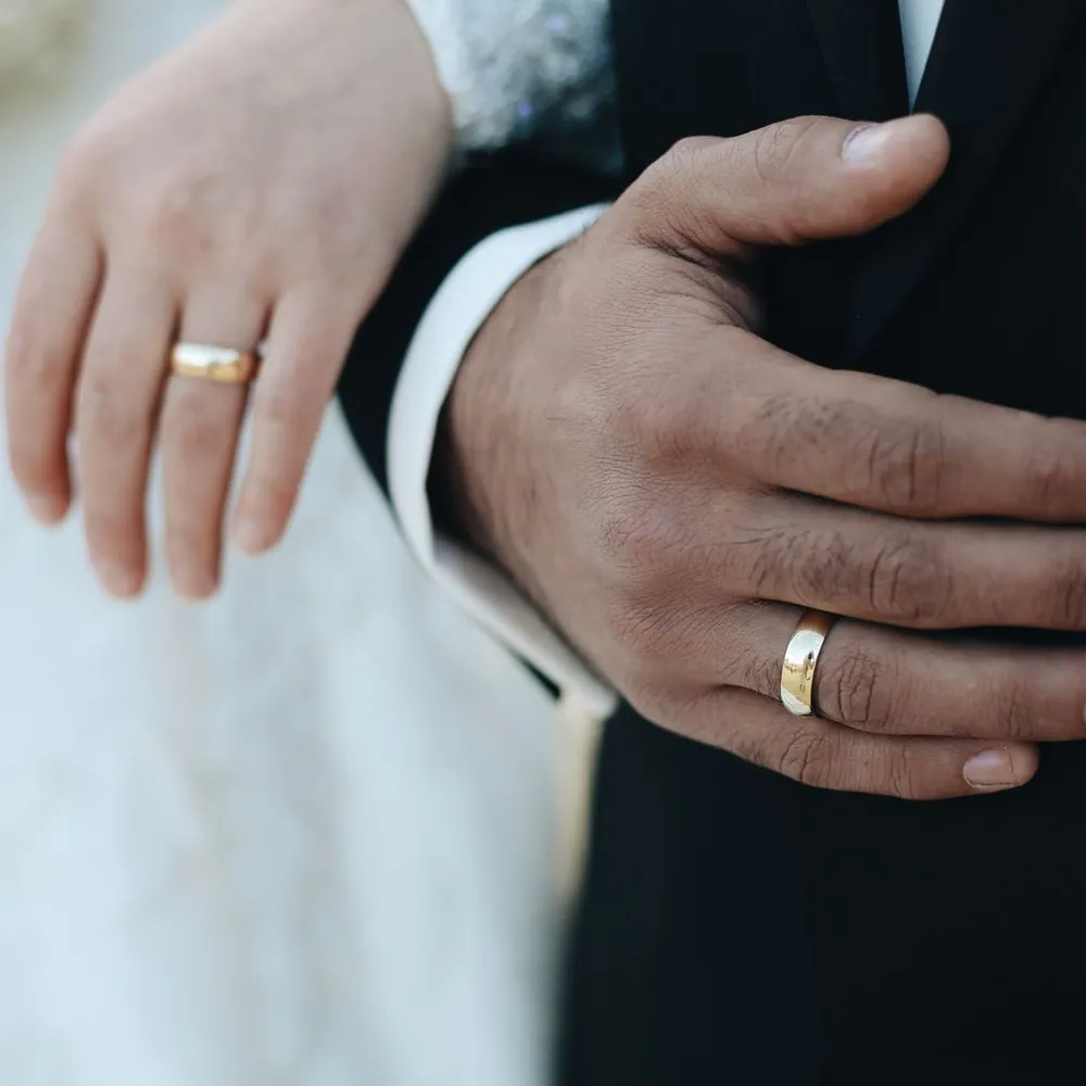 Primer plano de las manos de los novios mostrando sus anillos de matrimonio