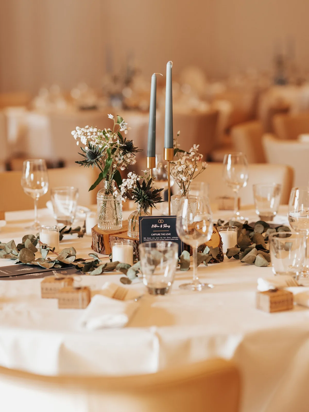 Mesa de banquete decorada con velas y arreglos florales en tonos cálidos