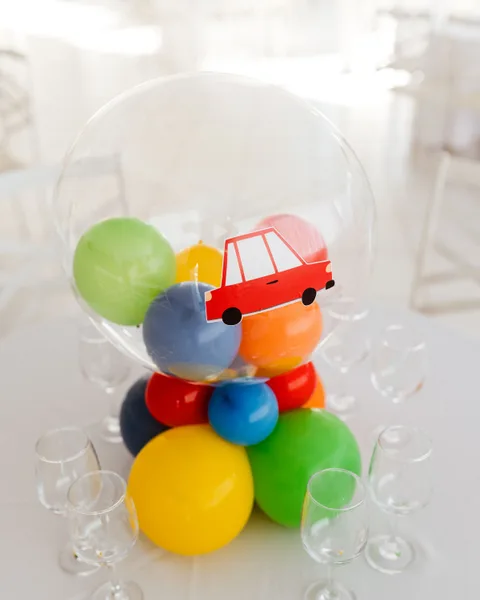 Arreglo de globos de colores con un cochecito de juguete